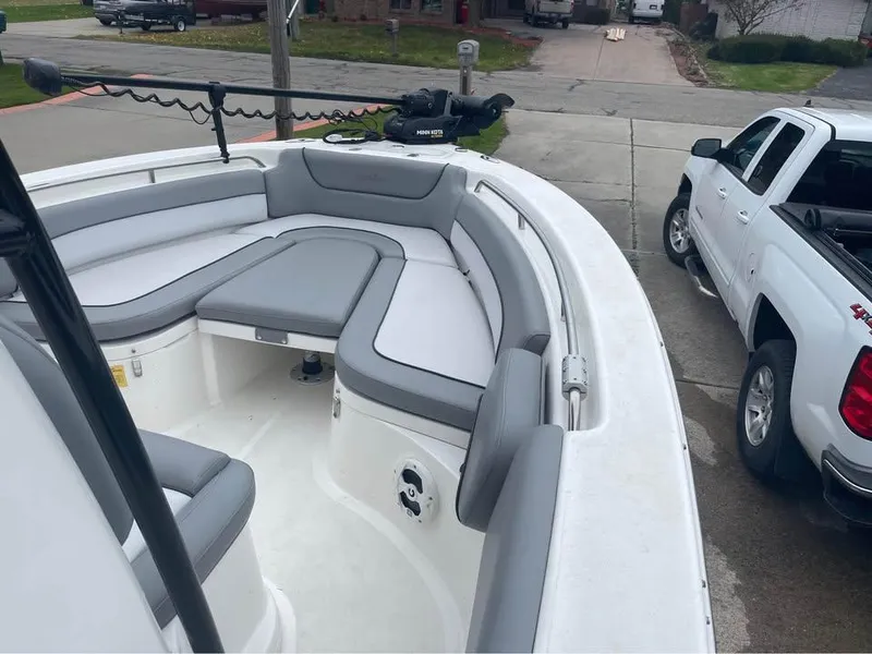 Slide: The Image of 2022 NauticStar 2302 Legacy boat with gray seating, parked near a white pickup truck. - 6