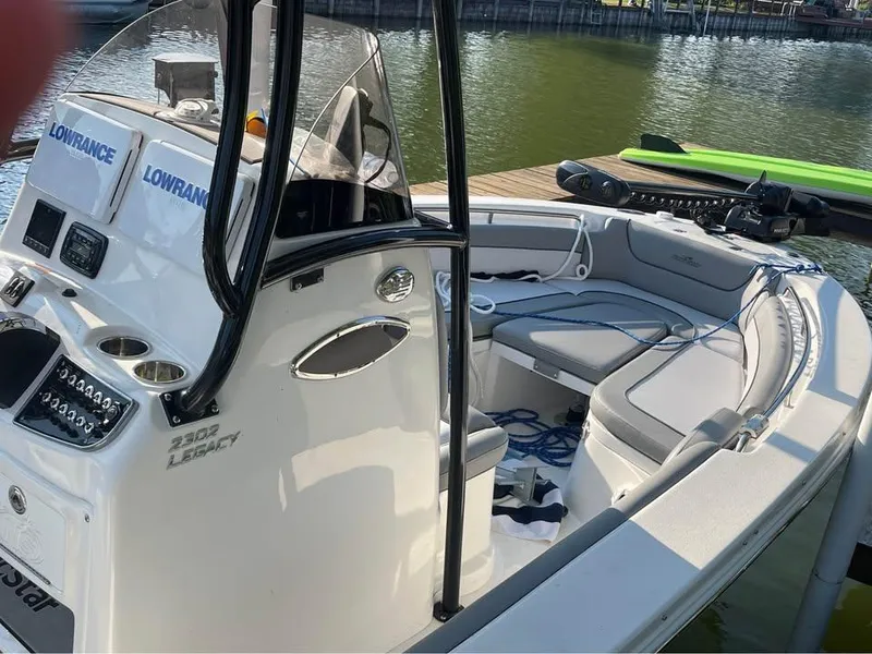 Slide: The Image of 2022 NauticStar 2302 Legacy boat interior with seating and navigation equipment. - 7