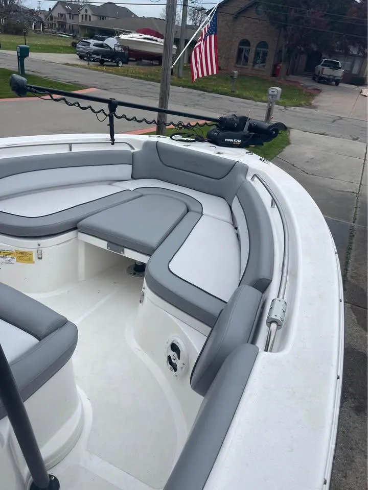 Slide: The Image of 2022 NauticStar 2302 Legacy boat with gray seating, docked near residential area. - 8