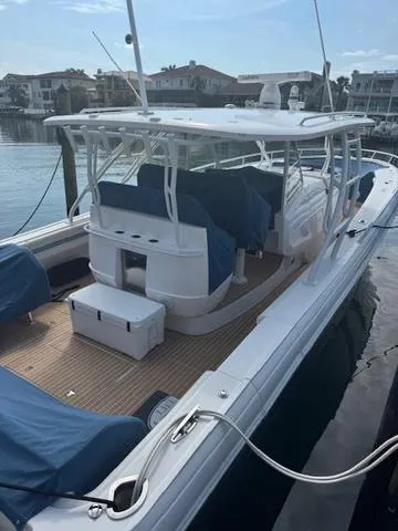 Slide: The Image of 2016 Intrepid 475 Panacea boat docked, featuring spacious deck and covered seating area. - 12