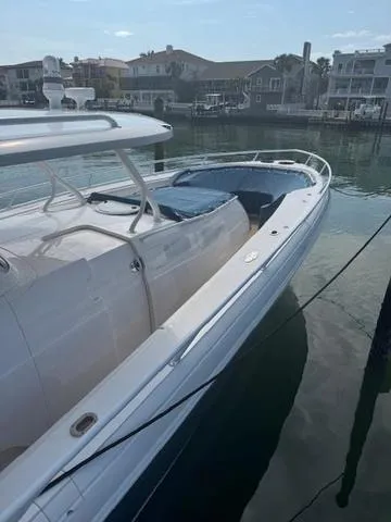 Slide: The Image of 2016 Intrepid 475 Panacea boat docked in a marina, showcasing sleek design and spacious deck. - 13