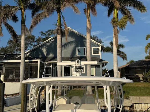 Slide: The Image of 2016 Intrepid 475 Panacea boat docked near a house with palm trees. - 23