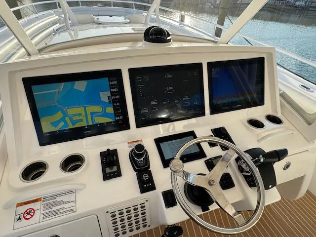 Slide: The Image of Control panel of a 2016 Intrepid 475 Panacea boat with navigation screens and steering wheel. - 24