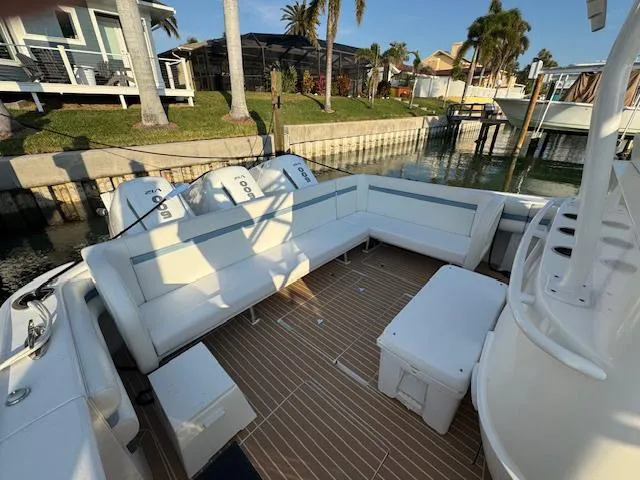 Slide: The Image of 2016 Intrepid 475 Panacea boat with spacious seating and outboard motors docked by a canal. - 32