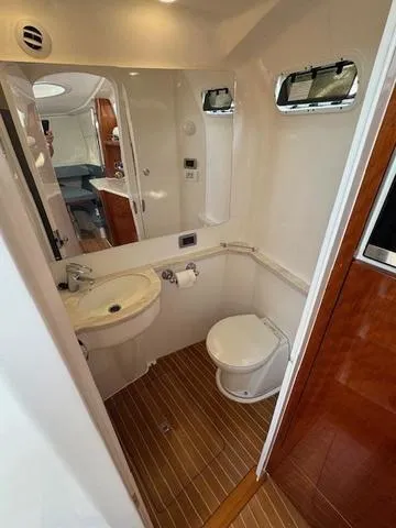 Slide: The Image of 2016 Intrepid 475 Panacea boat bathroom with modern fixtures and wooden accents. - 35