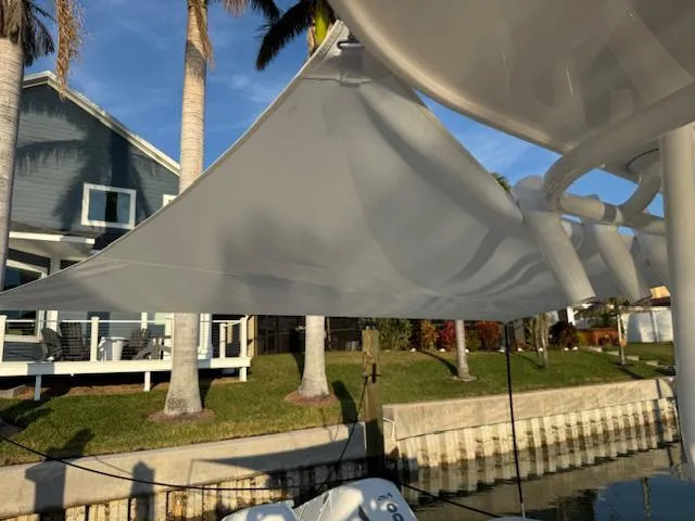 Slide: The Image of 2016 Intrepid 475 Panacea boat with sunshade, docked near a waterfront house. - 42