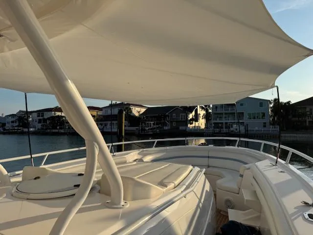 Slide: The Image of 2016 Intrepid 475 Panacea boat with canopy, docked near waterfront homes. - 48