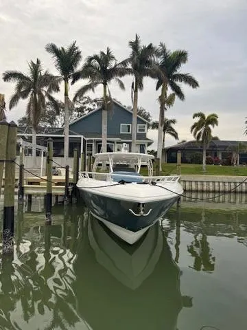 Slide: The Image of 2016 Intrepid Panacea boat docked by a waterfront house with palm trees. - 8