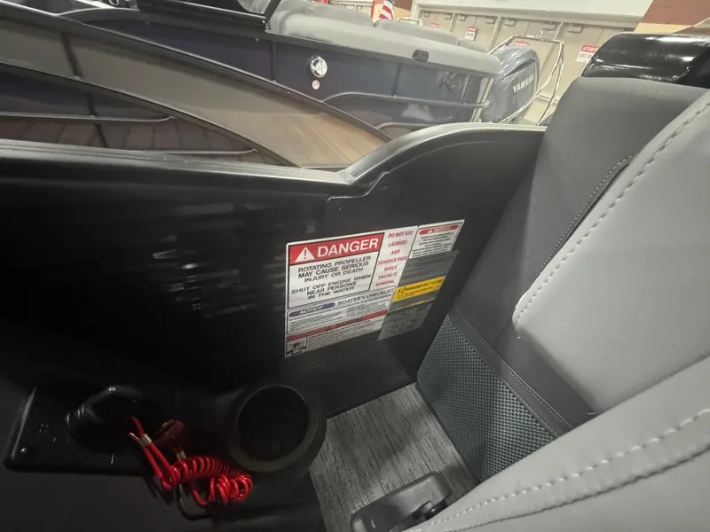 Slide: The Image of 2025 Bennington 24MFB-SPS (TC) boat interior with safety warning labels and cup holder. - 10