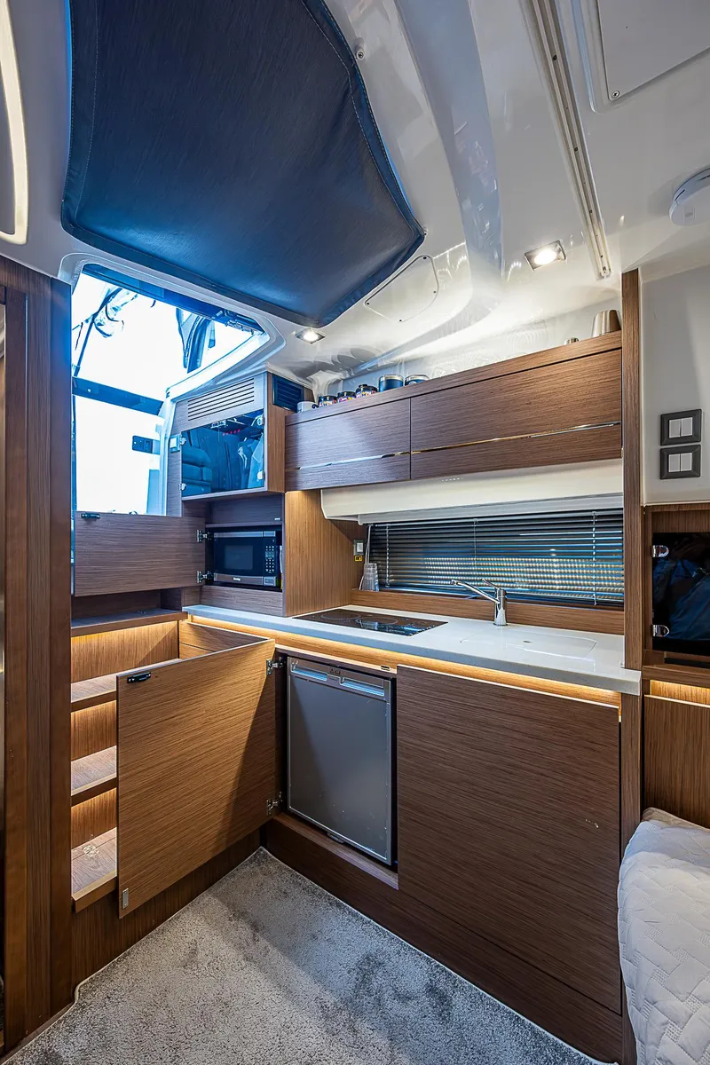Slide: The Image of Modern kitchen interior of 2022 Jeanneau Leader 12.5 yacht with wood cabinetry and appliances. - 14