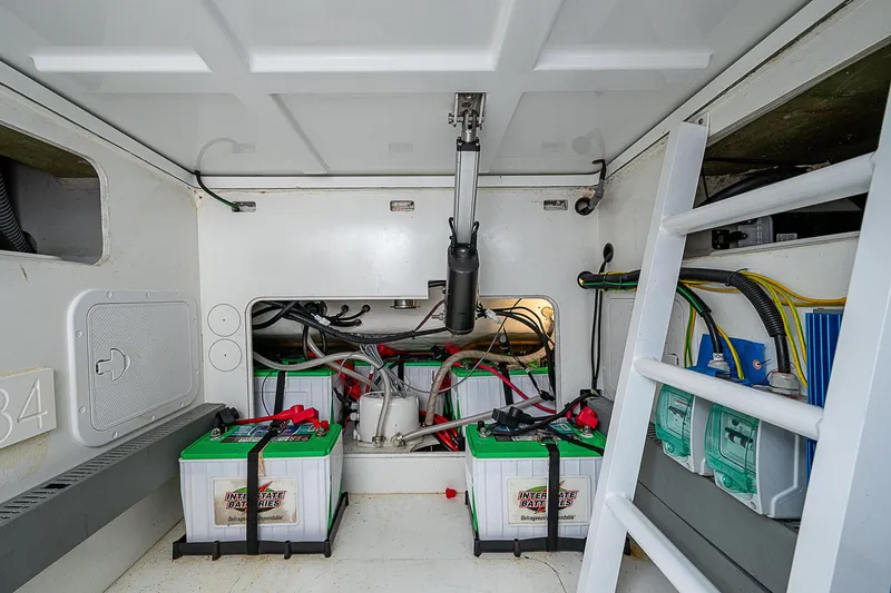 Slide: The Image of Battery compartment of 2022 Jeanneau Leader 12.5 boat, featuring multiple batteries and wiring. - 32
