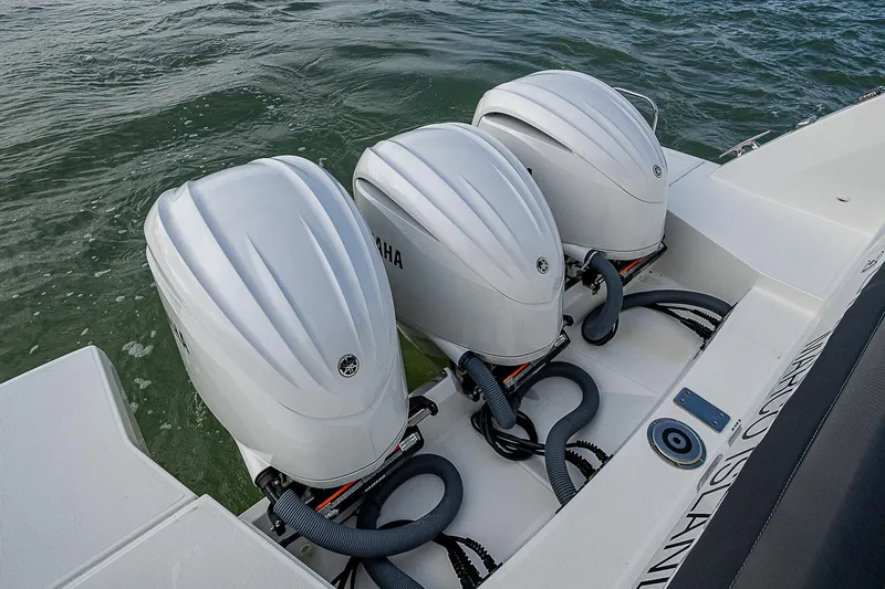 Slide: The Image of Triple Yamaha outboard engines on 2022 Jeanneau Leader 12.5 boat in water. - 34