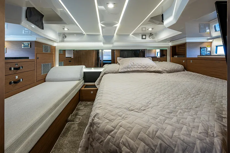 Slide: The Image of 2022 Jeanneau Leader 12.5 cabin interior with modern bedding and wood accents. - 37