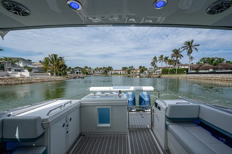 Slide: The Image of 2022 Formula 430 All Sport Crossover boat interior with waterfront view and palm trees. - 16