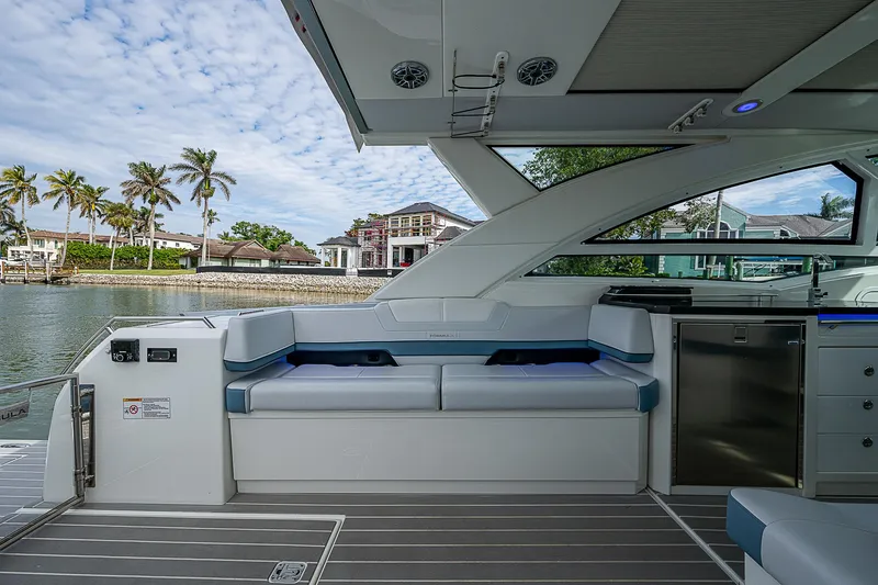 Slide: The Image of 2022 Formula 430 All Sport Crossover interior with seating, overlooking waterfront and palm trees. - 20