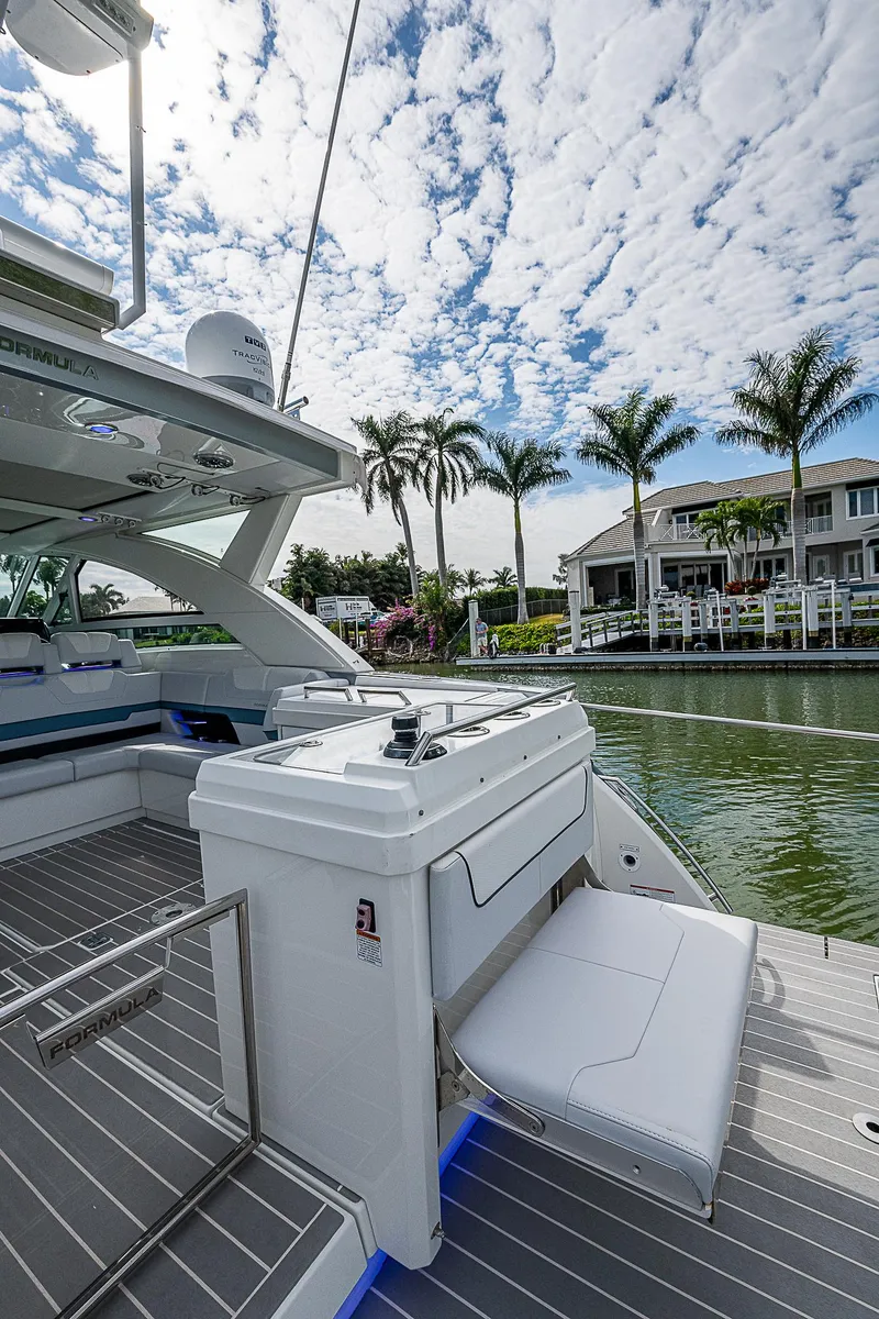 Slide: The Image of 2022 Formula 430 All Sport Crossover yacht docked by waterfront homes under a cloudy sky. - 24