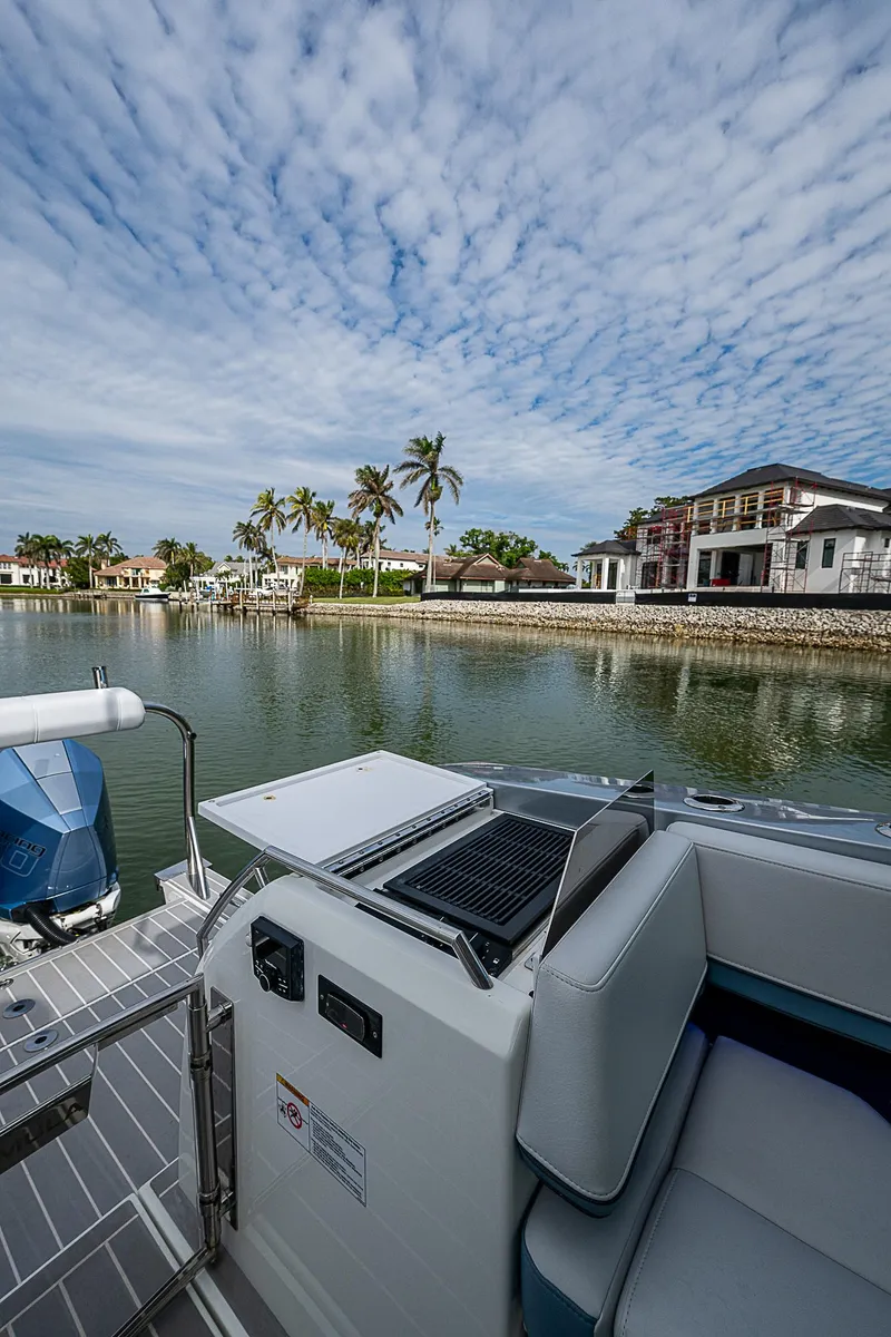 Slide: The Image of 2022 Formula 430 All Sport Crossover boat on a scenic waterfront with palm trees. - 25