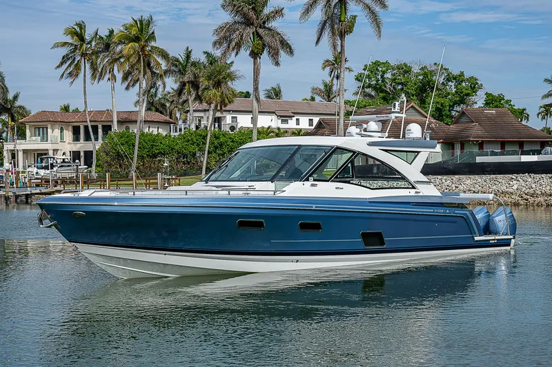 Slide: The Image of 2022 Formula 430 All Sport Crossover boat on calm water, surrounded by palm trees. - 3