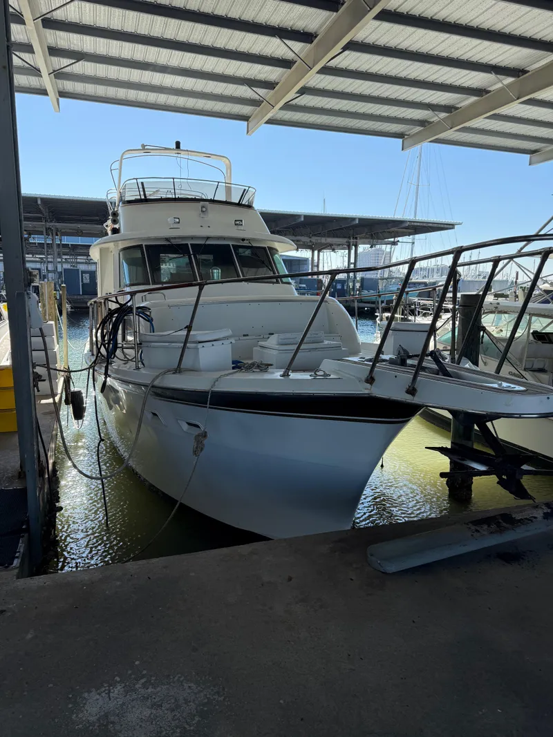 Slide: The Image of 1980 Hatteras 58MY yacht docked in a covered marina. - 0