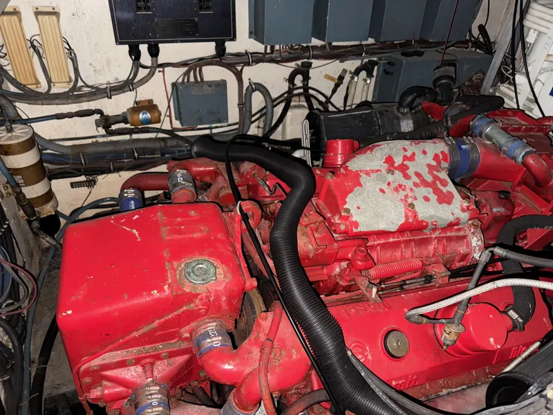 Slide: The Image of Engine room of a 1980 Hatteras 58MY yacht, featuring a red engine and various components. - 20
