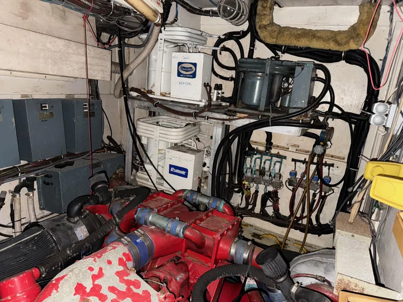 Slide: The Image of Engine room of 1980 Hatteras 58MY yacht, featuring mechanical components and wiring. - 21
