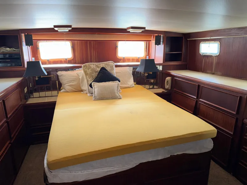 Slide: The Image of Interior of 1980 Hatteras 58MY yacht bedroom with yellow bedding and wooden cabinetry. - 24