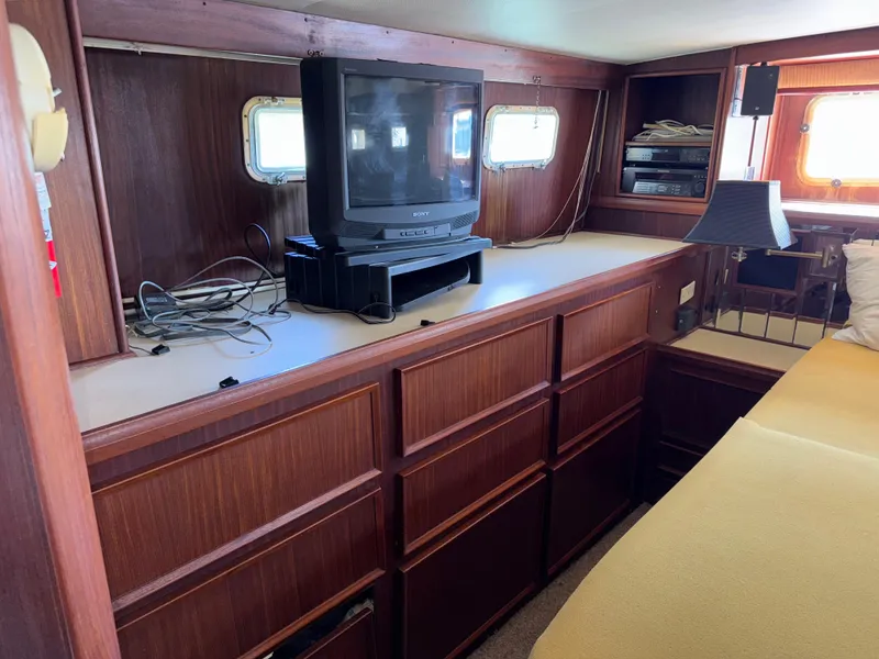 Slide: The Image of 1980 Hatteras 58MY interior with vintage TV, wooden cabinetry, and cozy seating area. - 25