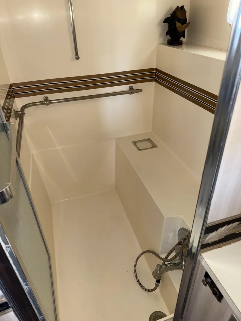Slide: The Image of 1980 Hatteras 58MY yacht bathroom with shower, bench, and handrails. - 28