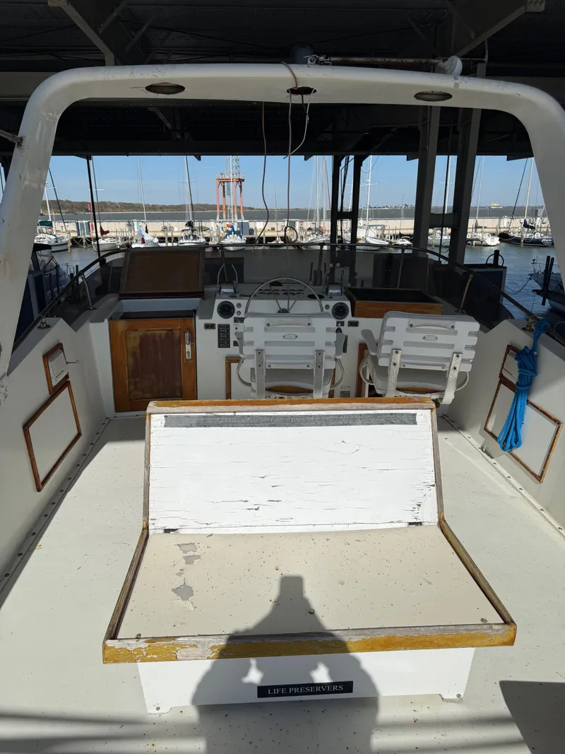Slide: The Image of 1980 Hatteras 58MY yacht interior with helm, seating, and marina view. - 29