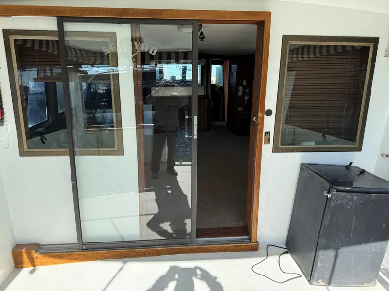 Slide: The Image of 1980 Hatteras 58MY yacht interior with sliding glass door and window blinds. - 4