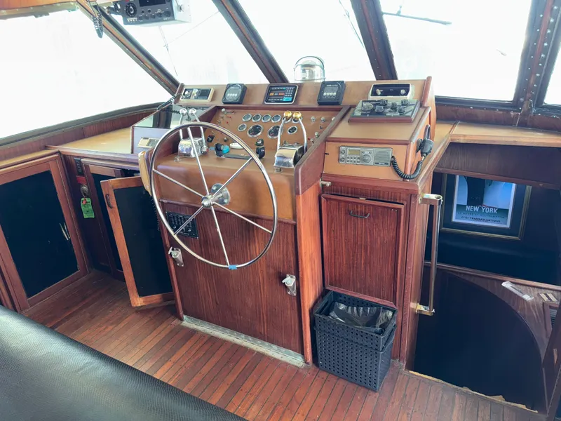 Slide: The Image of 1980 Hatteras 58MY yacht helm with wooden dashboard and steering wheel. - 8