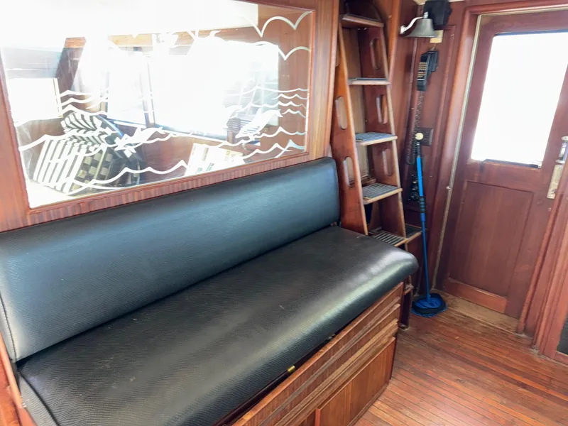 Slide: The Image of Interior of 1980 Hatteras 58MY yacht with black bench and wooden accents. - 9