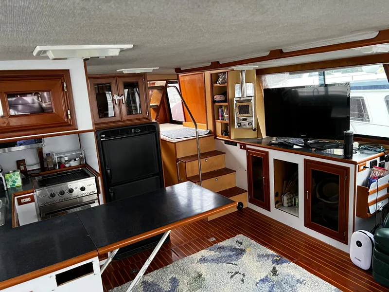 Slide: The Image of Interior of a 1990 Nova 4500 boat with kitchen, dining area, and entertainment setup. - 10