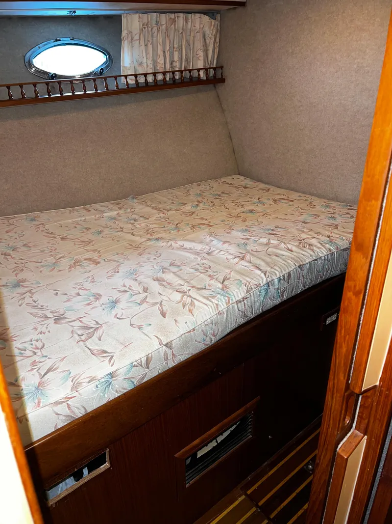 Slide: The Image of Cozy cabin bed in a 1990 Nova 4500 boat with floral bedding. - 13