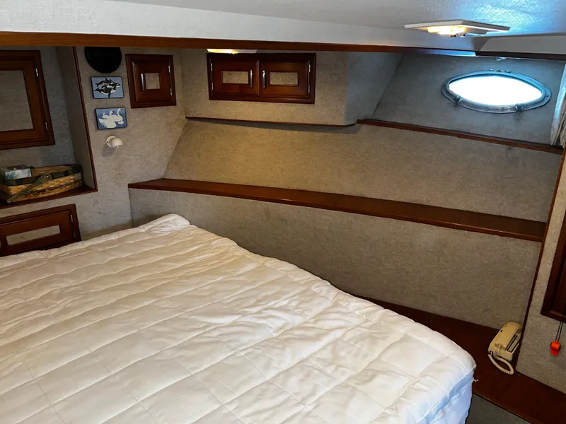 Slide: The Image of Cozy bedroom interior in a 1990 Nova 4500 boat with wood accents and porthole window. - 15
