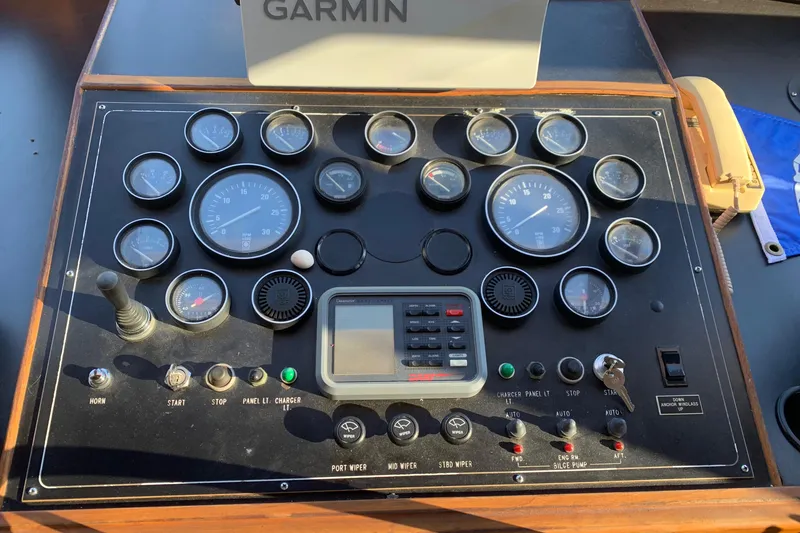Slide: The Image of Control panel of a 1990 Nova 4500 boat with gauges and Garmin device. - 23