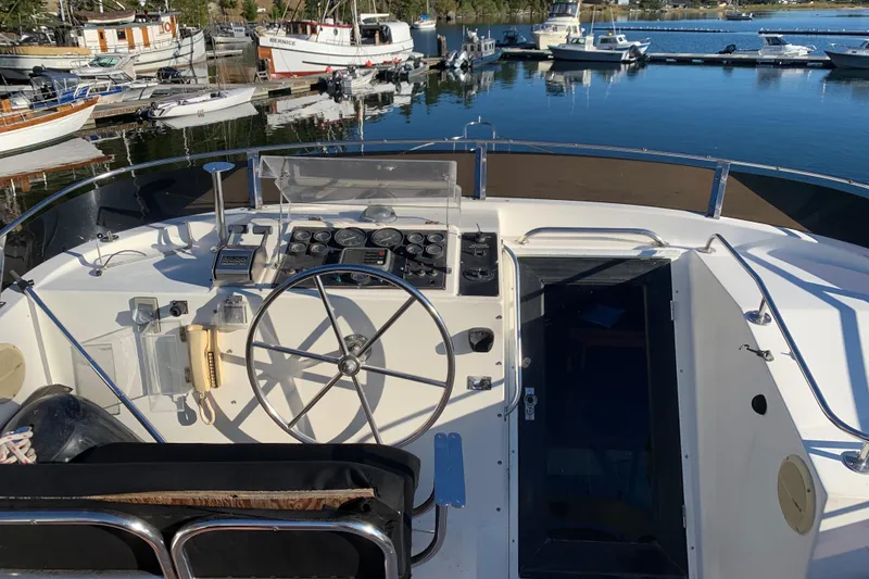 Slide: The Image of Helm of 1990 Nova 4500 boat with steering wheel, docked at marina. - 26