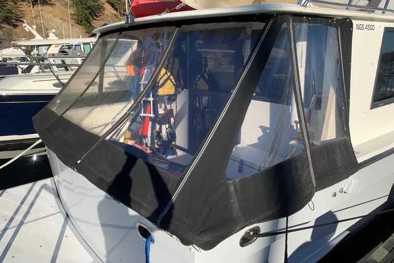 Slide: The Image of Nova 4500 boat from 1990 with black canvas enclosure in a marina setting. - 30