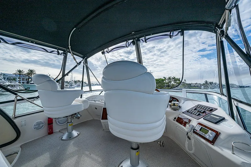 Slide: The Image of 2001 Sea Ray 400 Sedan Bridge cockpit with white captain chairs and panoramic view. - 11