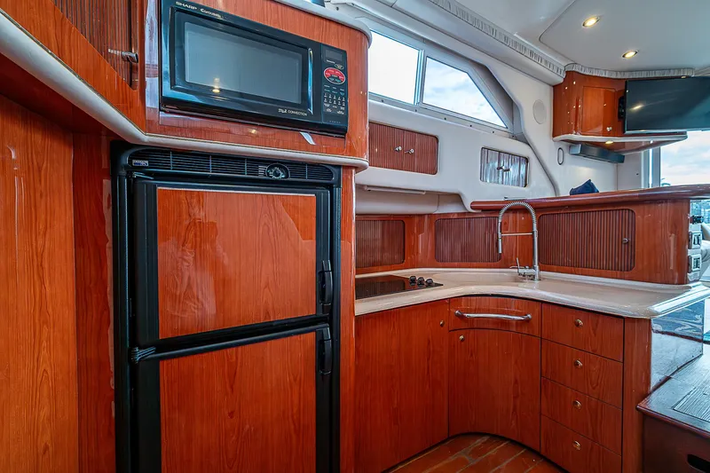 Slide: The Image of Interior of 2001 Sea Ray 400 Sedan Bridge yacht kitchen with wood cabinetry and appliances. - 26