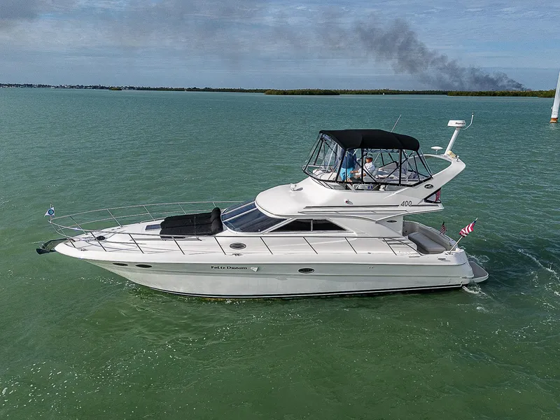 Slide: The Image of 2001 Sea Ray 400 Sedan Bridge yacht cruising on calm waters. - 4