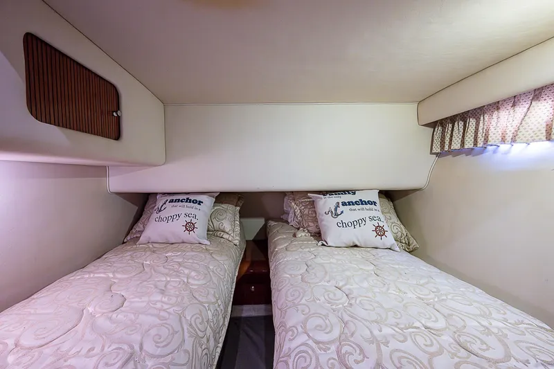 Slide: The Image of Twin beds in the 2001 Sea Ray 400 Sedan Bridge cabin, featuring nautical-themed pillows. - 41
