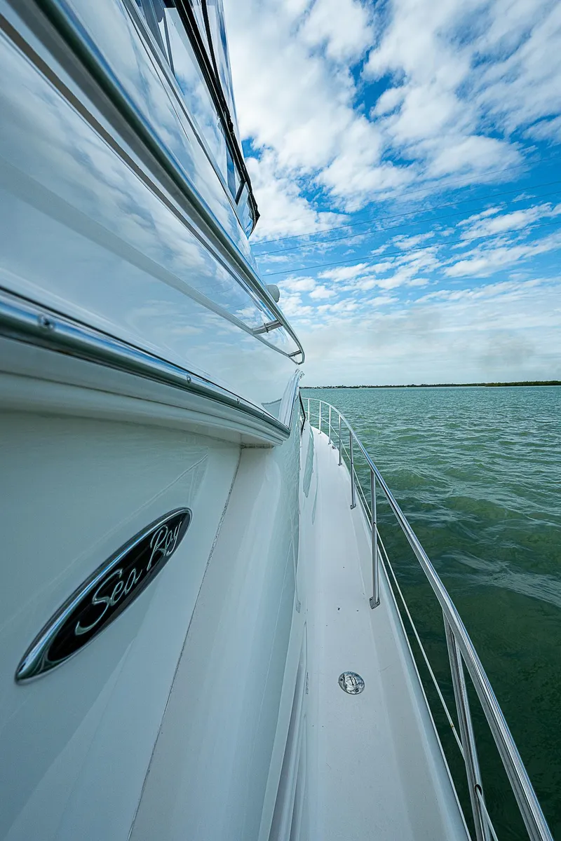 Slide: The Image of Side view of 2001 Sea Ray 400 Sedan Bridge yacht on open water under blue sky. - 43