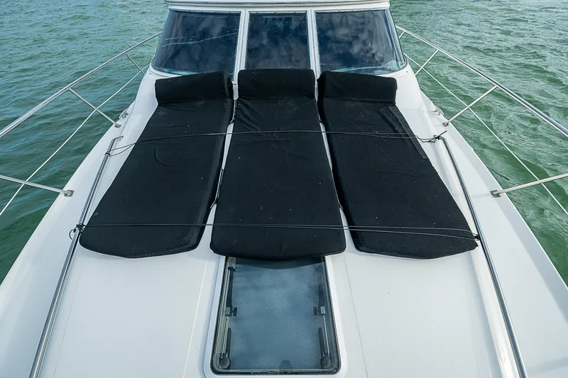 Slide: The Image of 2001 Sea Ray 400 Sedan Bridge yacht with black sun pads on deck. - 46