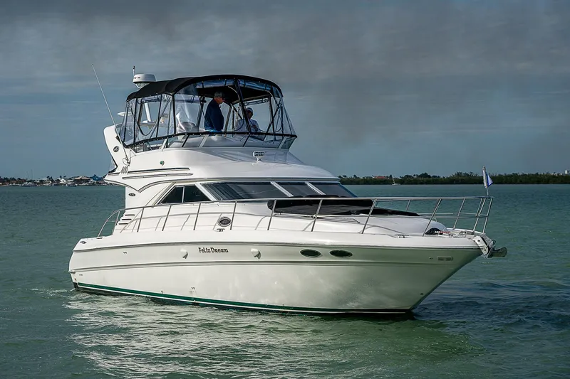 Slide: The Image of 2001 Sea Ray 400 Sedan Bridge yacht cruising on calm waters. - 49