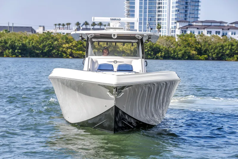 Slide: The Image of 2019 Fountain 43NX boat cruising on water with cityscape background. - 10