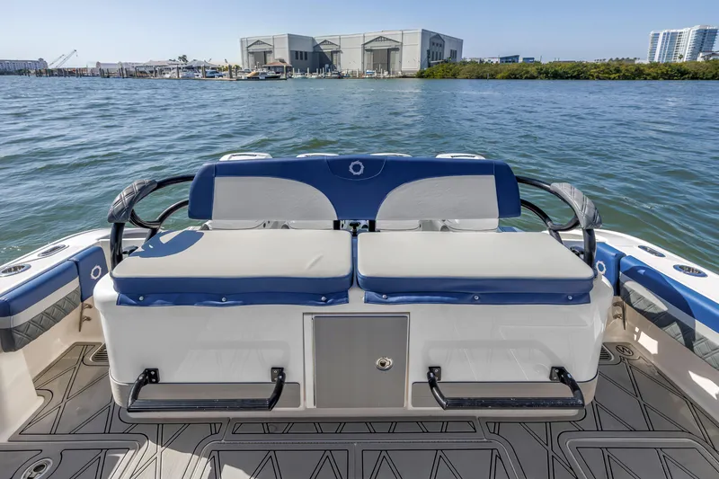 Slide: The Image of 2019 Fountain 43NX boat with cushioned seating, docked near waterfront buildings. - 13