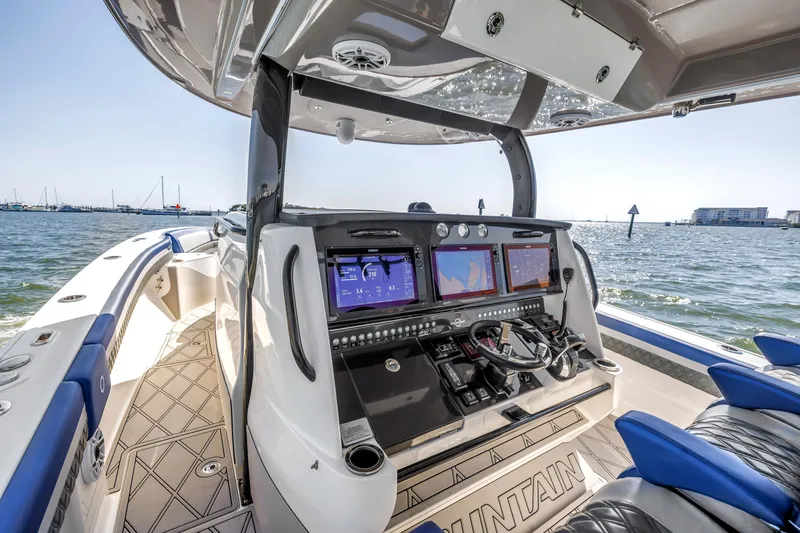 Slide: The Image of Cockpit of 2019 Fountain 43NX boat with advanced navigation systems, on a sunny day at sea. - 16