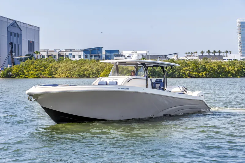 Slide: The Image of 2019 Fountain 43NX boat cruising on a sunny day near modern buildings. - 2