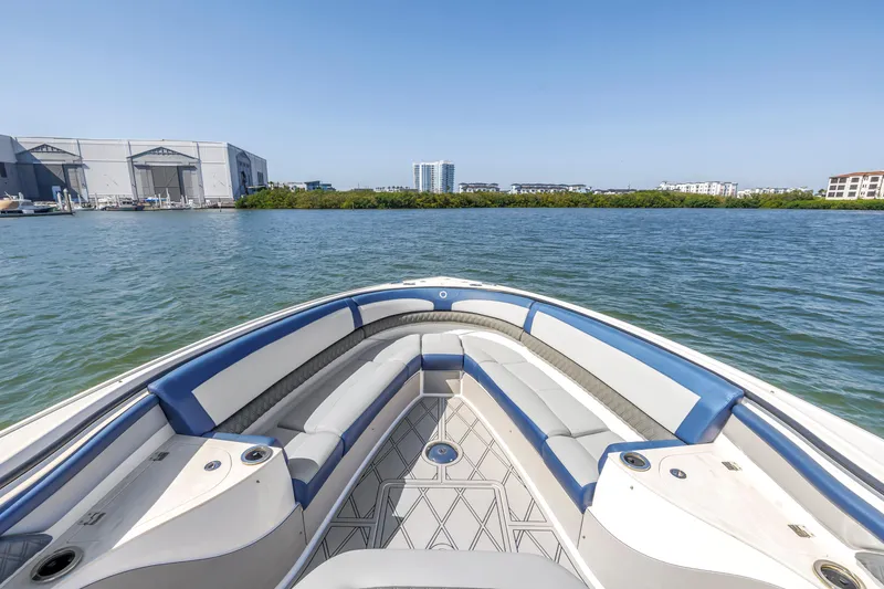 Slide: The Image of Bow view of 2019 Fountain 43NX boat on calm water, with modern seating and clear sky. - 20